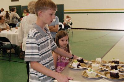 Sunday Party at OLS School
Cake: Riley Hughes assists with cake serving.  Julia Higham helps.
