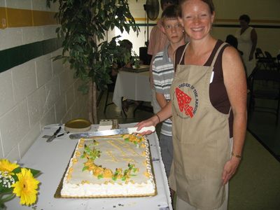 Sunday Party at OLS School
Cake:  Ann Higham Hughes prepares to serve cake with Riley ready to help.
